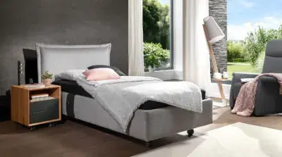 Modernes Boxspringbett im Schlafzimmer mit Tageslicht, Fenster und Sessel